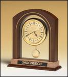 Arched pendulum clock with walnut and 
burl finish, three-hand movement
